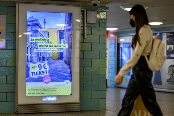 A commuter walks past a digital billboard displaying an ad for the so-called "9-euro-ticket" in the Alexanderplatz U-bahn subway station in Berlin on May 31, 2022. (Photo by John MacDougall/AFP via Getty Images)