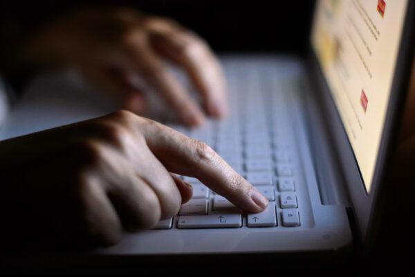 A woman using a laptop in an unspecified location, on Aug. 6, 2013. (PA Media)