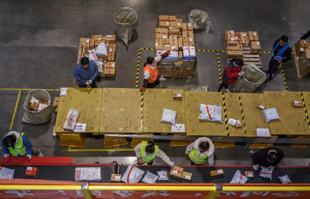 Workers from Chinese e-commerce giant JD.com prepare parcels for delivery at the company's main logistics hub during an organized tour for Singles Day on Nov. 11, 2020, in Beijing, China. (Kevin Frayer/Getty Images)