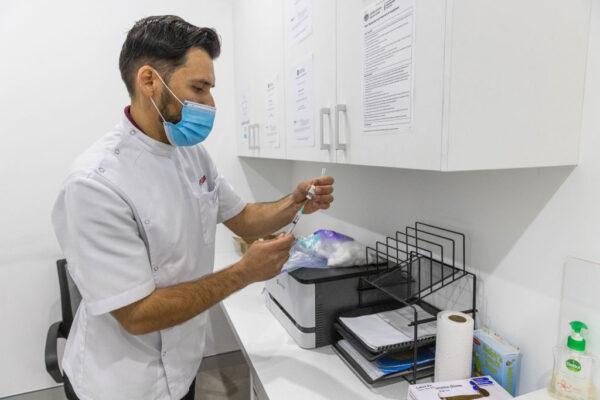 A pharmacist is seen preparing a Covid-19 vaccine at the Pharmacy 4 Less M-City Clayton in Melbourne, Australia, on July 11, 2022. (Asanka Ratnayake/Getty Images)