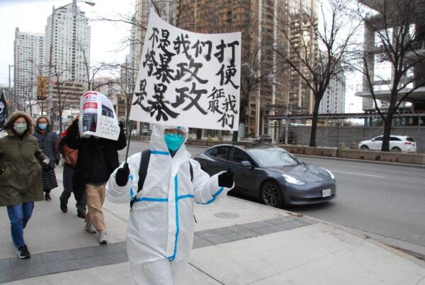 A protester in Toronto holds a sign reading "Either we defeat tyranny, or tyranny conquers us" in Toronto on Nov. 19, 2022. A group made up of Chinese students and dissidents protesting Beijing's zero-COVID policies held a rally calling for an end to the Chinese communist regime. (Michelle Hu/The Epoch Times)