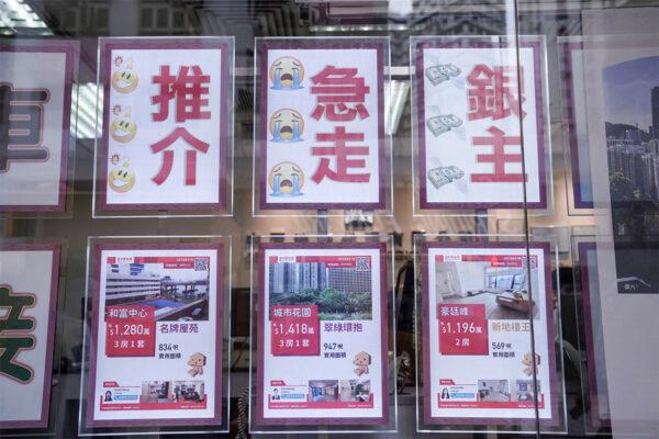 There were increased advertisements for emigrants selling their properties during October and November 2022. This picture shows a real estate agency on Hong Kong Island posting advertisements at the front window showing "Urgent Sales" of some eminent housing estates. (Adrain Yu/The Epoch Times)