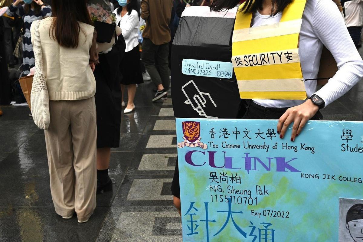 A demonstrator displayed an enlarged spoof" student ID card to protest against the school's restriction of free access to the campus. (Facebook picture of University Community Press)