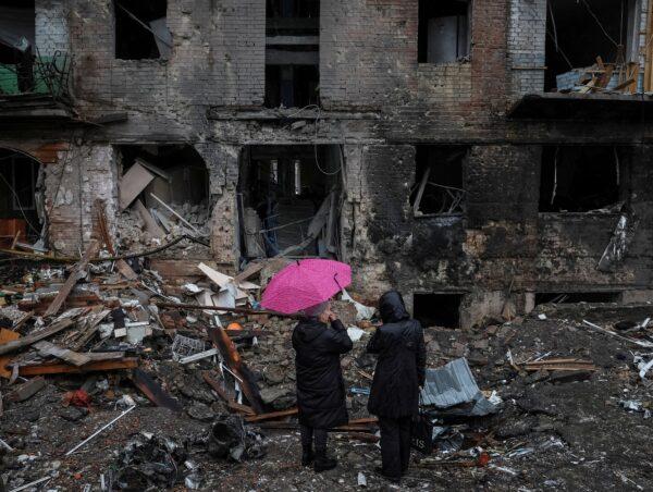 As Russia's attack on Ukraine continues, local residents stand near their building destroyed by a Russian missile attack in the town of Vyshhorod, near Kyiv, Ukraine, on Nov. 24, 2022. (Gleb Garanich/Reuters)