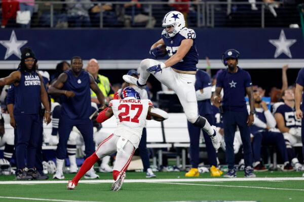 Jake Ferguson (87) of the Dallas Cowboys jumps over Jason Pinnock (27) of the New York Giants during the second half at AT&T Stadium in Arlington, Texas, on Nov. 24, 2022. (Wesley Hitt/Getty Images)