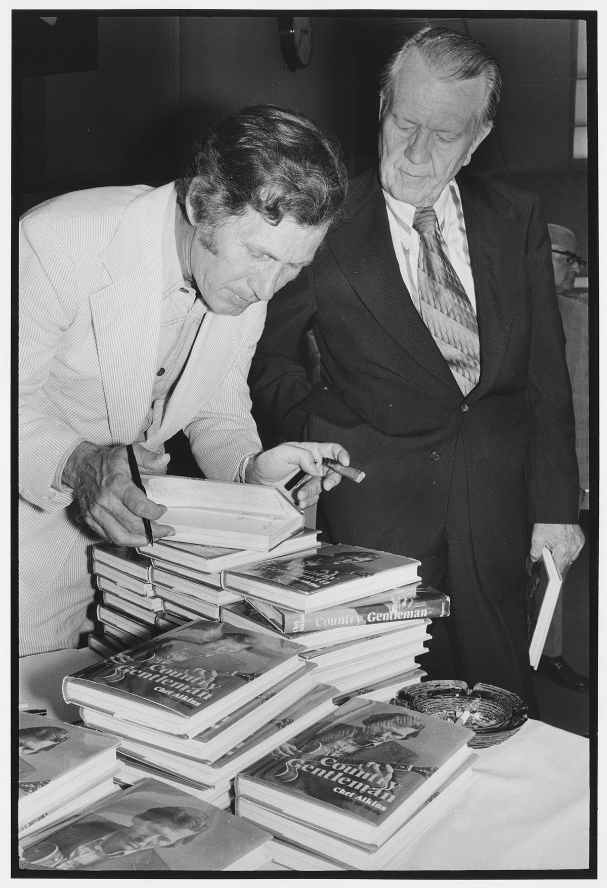Country musician Chet Atkins signing a copy of his book "Country Gentleman." (Public Domain)