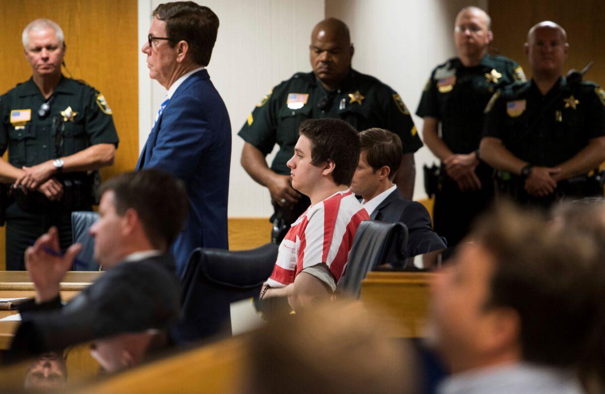 Austin Harrouff (C), wearing stripes, accused of brutally killing a Tequesta couple in 2016, appears at the Martin County Courthouse in Stuart, Fla., on Aug. 2, 2019. (Xavier Mascarenas/TCPalm.com via AP)