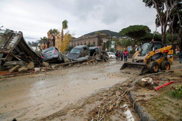 Rescuers remove mud from a street after heavy rainfall triggered landslides that collapsed buildings and left as many as 12 people missing, in Casamicciola, on the southern Italian island of Ischia, Italy, on Nov. 26, 2022. (Salvatore Laporta/AP Photo)