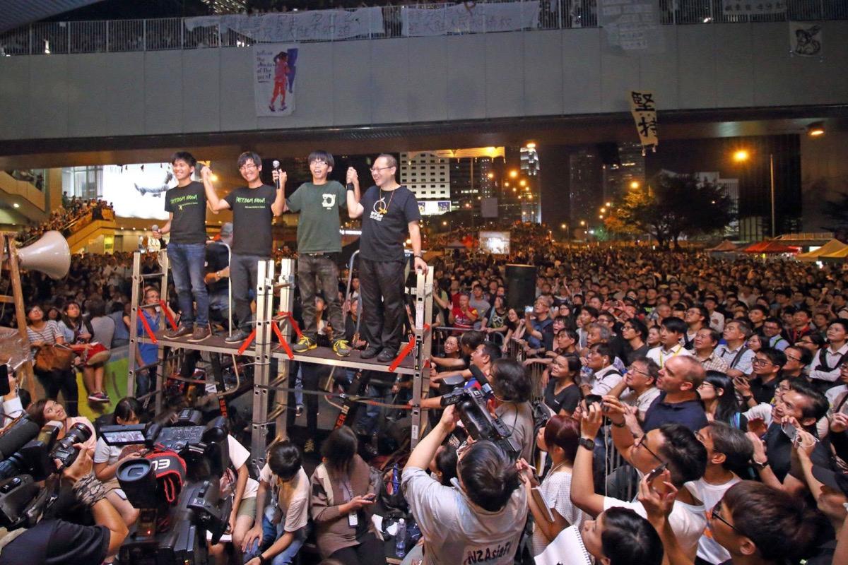 The Hong Kong government canceled a dialogue meeting with the Hong Kong Federation of Students (HKFS), causing 100,000 people to gather around the government headquarters in Admiralty on the evening of Oct. 10, 2020. The 100,000 people demanded the then Chief Executive of Hong Kong, pro-CCP CY Leung Chun-ying, accused of corruption, to step down. The then three student activists (left to right), Lester Shum, Alex Chow, Joshua Wong, and Occupy Central Convener Prof. Benny Tai Yiu-ting, called on citizens to resist to the end. (Cai Wenwen/The Epoch Times）