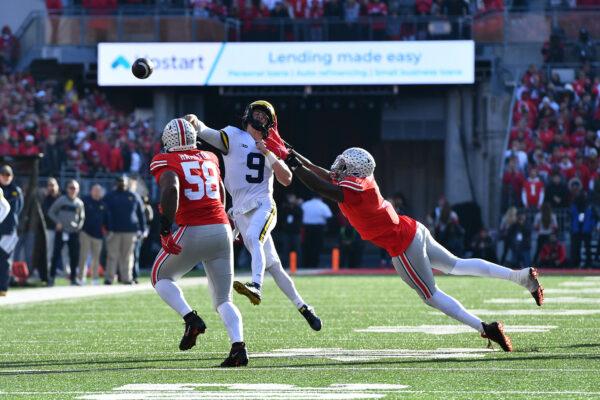 J.J. McCarthy (9) of the Michigan Wolverines throws the ball away from Zach Harrison (9) of the Ohio State Buckeyes during the fourth quarter of a game at Ohio Stadium in Columbus, Ohio, on November 26, 2022. (Ben Jackson/Getty Images)