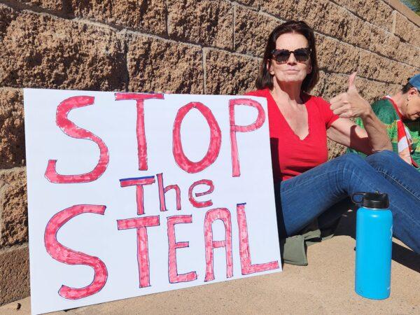 Anne Howell of Phoenix holds a sign proclaiming her view on Arizona's midterm election at a grassroots "sit-in" at the veterans memorial in Phoenix on Nov. 25. (Allan Stein/The Epoch Times)