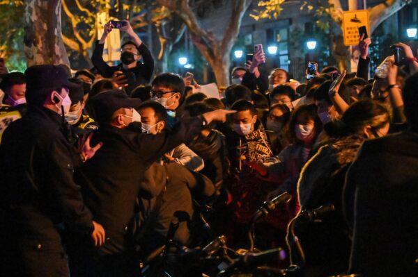 Police and people are seen during some clashes in Shanghai on Nov. 27, 2022, where protests against China's zero-COVID policy took place the night before following a deadly fire in Urumqi, the capital of the Xinjiang region. (Hector Retamal/AFP via Getty Images)