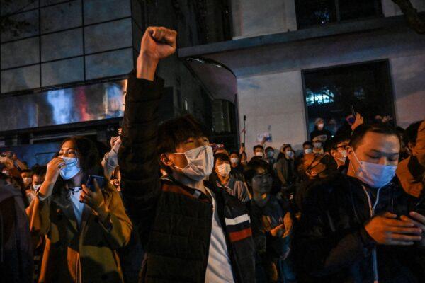 People sing slogans while gathering on a street in Shanghai on Nov. 27, 2022.(Hector Retamal/AFP via Getty Images)