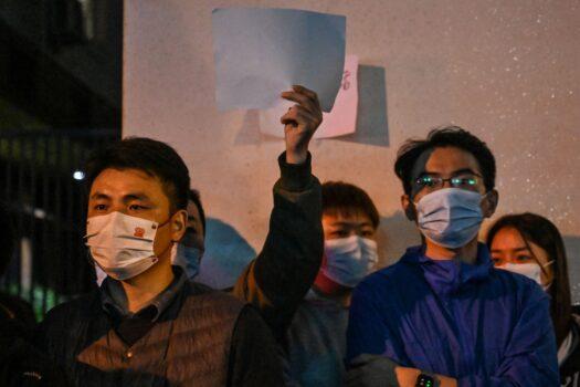 People show blank papers as a way to protest on a street in Shanghai on Nov. 27, 2022, where protests against China's zero-COVID policy took place the night before following a deadly fire in Urumqi, the capital of the Xinjiang region. (Hector Retamal/AFP via Getty Images)