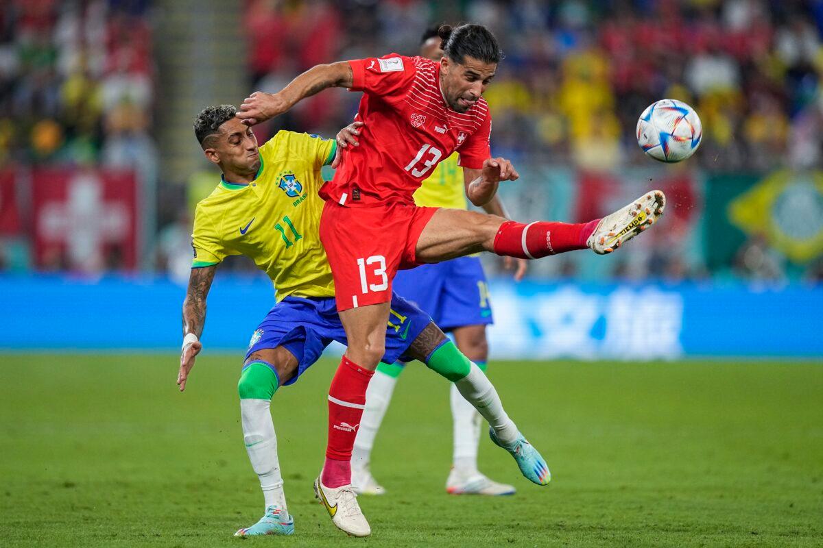 Switzerland's Ricardo Rodriguez (R) vies for the ball with Brazil's Raphinha during the World Cup group G soccer match between Brazil and Switzerland, at the Stadium 974 in Doha, Qatar, on Nov. 28, 2022. (Ariel Schalit/AP Photo)