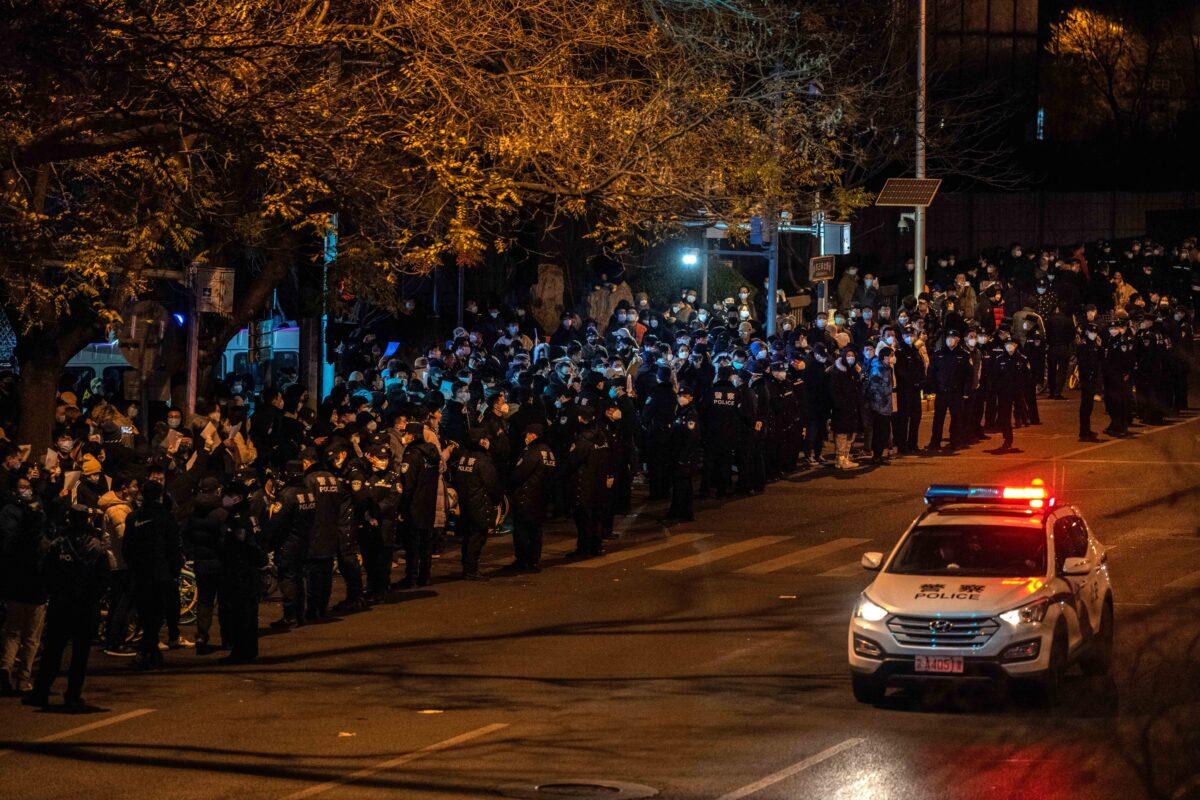 Protesters and police gather during a protest against China's strict zero-COVID measures in Beijing on Nov. 28, 2022. (Kevin Frayer/Getty Images)