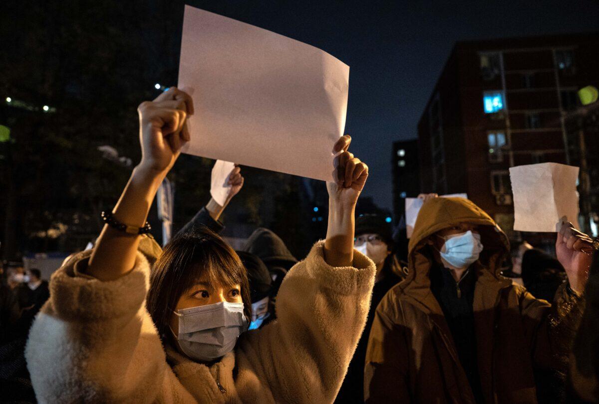 Protesters hold up pieces of paper against censorship and China's strict 'zero-COVID' measures in Beijing on Nov. 27, 2022. Protesters took to the streets in multiple Chinese cities after a deadly apartment fire in Xinjiang sparked a national outcry as many blamed COVID restrictions for the deaths. (Kevin Frayer/Getty Images)