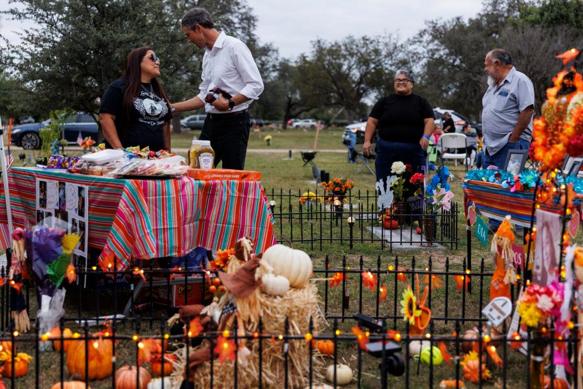Sandra Cruz Torres, mother of Robb Elementary shooting victim Eliahna Torres, chats with Beto O'Rourke, Democratic candidate running for governor, as Cruz and her family celebrate Día de los Muertos at Torres' gravesite in Hillcrest Memorial Cemetery in Uvalde, Texas, on Nov. 2, 2022. (Sam Owens/The San Antonio Express-News via AP)