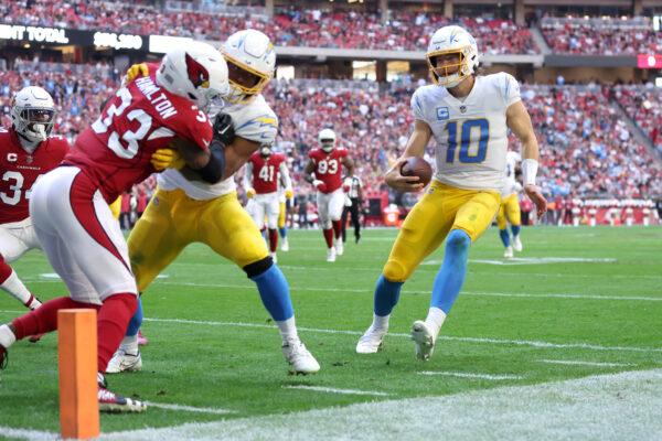 Justin Herbert (10) of the Los Angeles Chargers runs for yards in the first half of a game against the Arizona Cardinals at State Farm Stadium in Glendale, Ariz., on Nov. 27, 2022. (Christian Petersen/Getty Images)