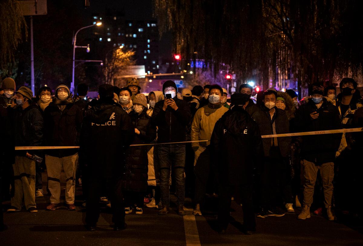 Police keep some protesters behind a cordon during a protest against the Chinese regime's strict zero-COVID measures in Beijing on Nov. 27, 2022. (Kevin Frayer/Getty Images)