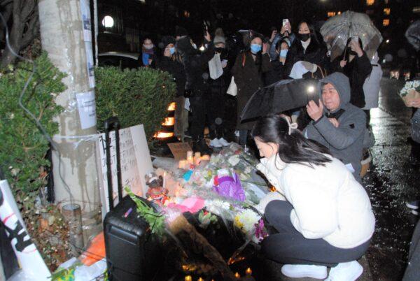 Protesters place flowers in front of the Chinese consulate to pay tribute to the victims who died in the apartment fire in Xinjiang’s capital of Urumqi, in Toronto on Nov. 27, 2022. (Michelle Hu/The Epoch Times)