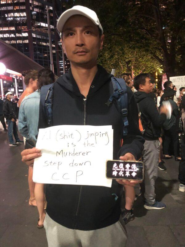 Andy Cai, an Australian resident from mainland China holding a sign. (Li Zhaohui/The Epoch Times)