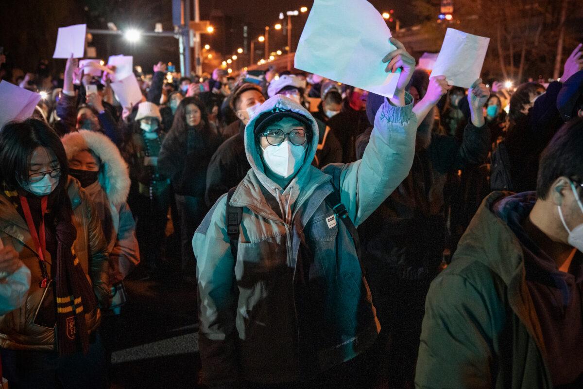 Demonstrators hold blank signs during a protest in Beijing on Nov. 28, 2022. (Bloomberg)