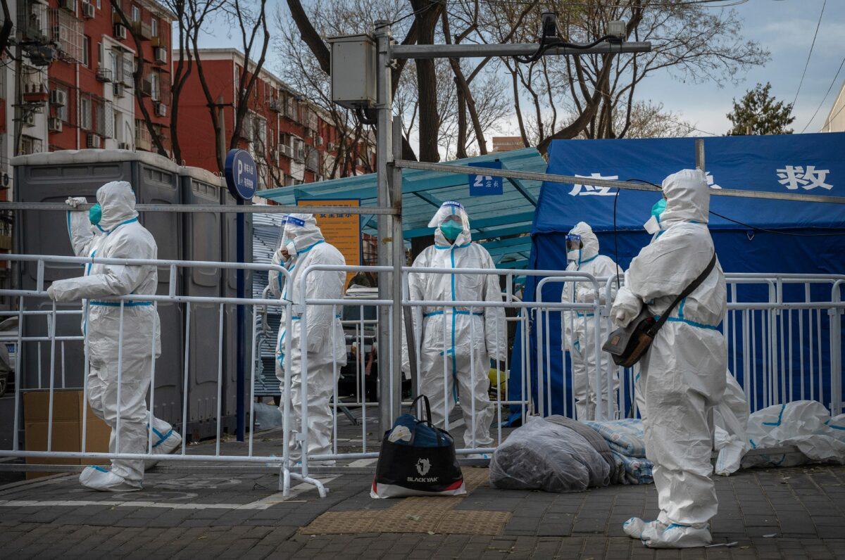 Epidemic control workers stand guard outside a community in lockdown in Beijing on Nov. 29, 2022.(Kevin Frayer/Getty Images)