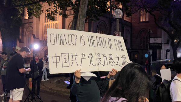 A protestor holding a slogan. (Ling Xiao/The Epoch Times)