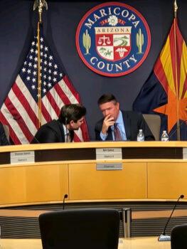 Maricopa County Board of Supervisors chairman Bill Gates (R) confers with another official before the board's canvass of the November midterm election in Phoenix on Nov. 28, 2022. (Allan Stein/The Epoch Times)