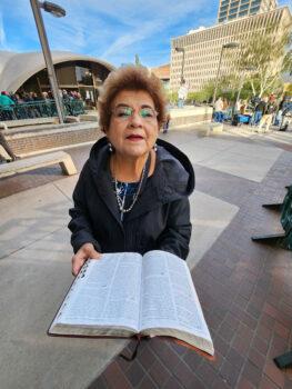 Lydia of Maricopa County reads from the Bible as she waits to enter the county board of supervisors conference center in Phoenix on Nov. 28, 2022. (Allan Stein/The Epoch Times)
