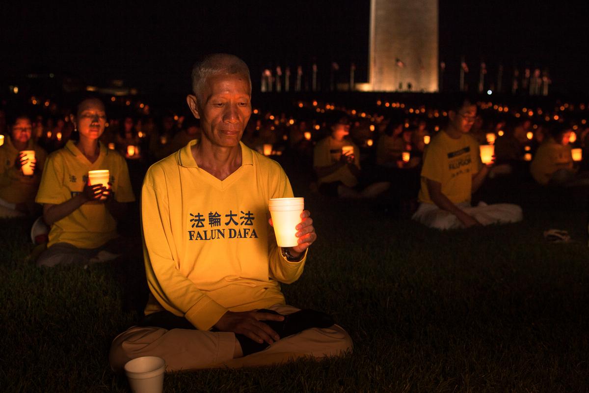 Practitioners of Falun Dafa (also Falun Gong) hold a candle light vigil to commemorate the 16 years their fellow practitioners have been facing persecution in China, by the Washington Monument on July 16, 2015. (Petr Svab/Epoch Times)