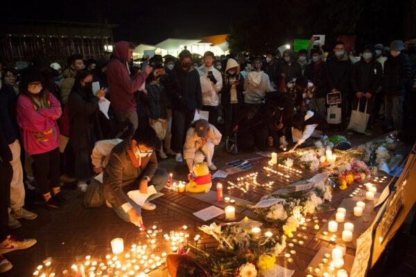 People light candles for a vigil at UC Berkeley’s Sather Gate on Nov. 28, 2022. (Lear Zhou/The Epoch Times)