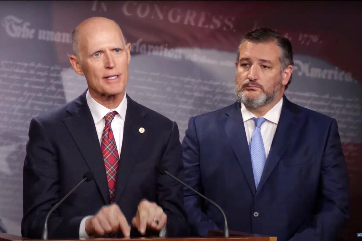 Sen. Rick Scott (R-Fla.) (L) speaks at a press conference demanding a Senate vote on ending the military COVID-19 vaccine mandate, as Sen. Ted Cruz (R-Texas) looks on in Washington on Nov. 30, 2022, in a still from a livestream released by NTD. (NTD)