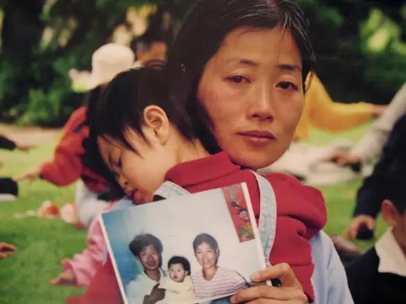Jane Dai with her daughter Fadu holds a picture of the family before of Fadu's father, Chen Chengyong, was tortured to death for practicing Falun Gong. (Mimi Li/The Epoch Times)