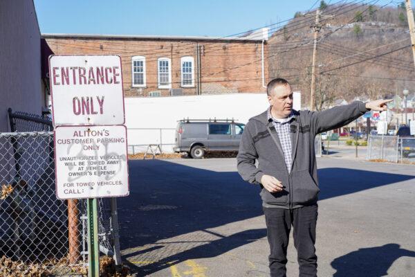 Michael Worden, standing where the jail once was, points to the route that Robert Lewis was dragged on by a mob in Port Jervis, N.Y., on Nov. 23, 2022. (Cara Ding/The Epoch Times)