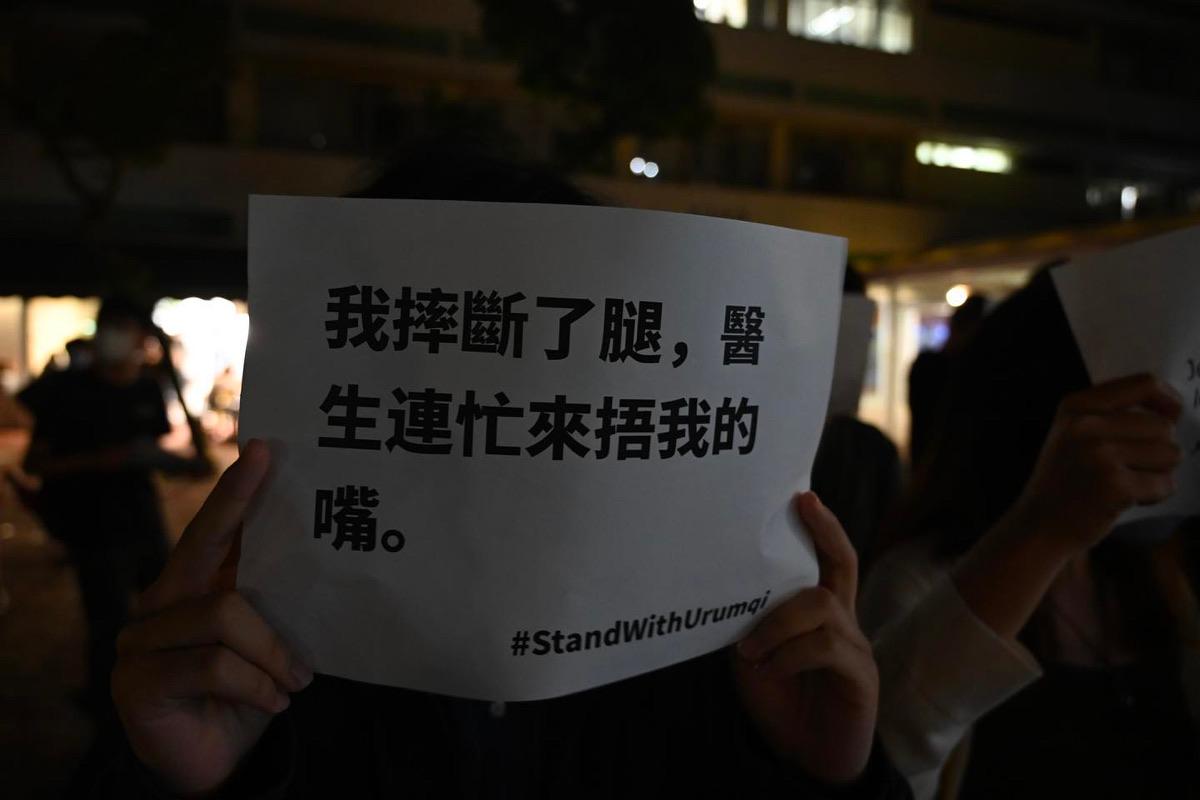A CUHK student held up a white paper with a message that read, "I broke my leg, and the doctor quickly came to cover my mouth." It satirizes the CCP's harsh Covid rules, saying that even the doctors who are supposed to "save lives” are acting absurdly. (Courtesy of University Community Press)