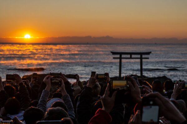 People gather in front of the torii gate of Oarai Isosaki shrine to watch the sunrise on New Year's Day in Oarai of Ibaraki Prefecture, Japan, on Jan. 1, 2023. (Philip Fong/AFP via Getty Images)