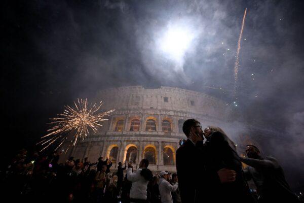 A couple kisses as fireworks are shot as part of celebrations for the New Year in downtown Rome, with the ancient Colosseum in the background, on Jan. 1, 2023. (Filippo Monteforte/AFP via Getty Images)