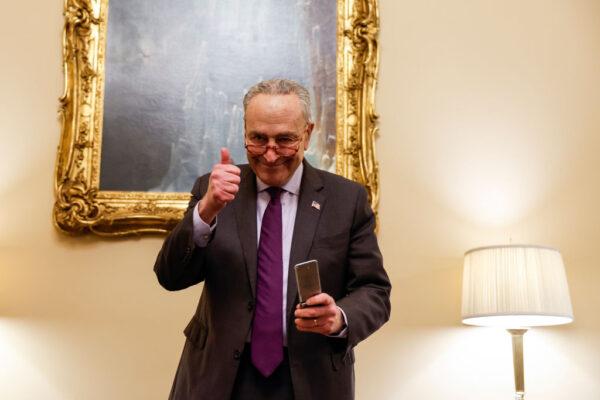 U.S. Senate Majority Leader Chuck Schumer (D-N.Y.) gives a thumbs up after speaking on the phone with his daughter Alison and Alison’s wife from his office after the Senate voted on the Respect for Marriage Act at the Capitol Building in Washington, on Nov. 29, 2022. The Senate voted 61–36 in favor of the measure providing federal recognition and protection for same-sex and interracial marriages. (Anna Moneymaker/Getty Images)