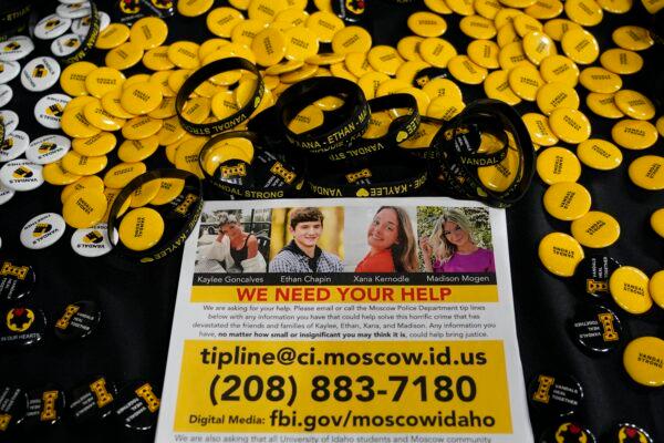 A flyer seeking information about the killings of four University of Idaho students who were found dead is displayed on a table along with buttons and bracelets during a vigil in memory of the victims in Moscow, Idaho, on Nov. 30, 2022. (Ted S. Warren/AP Photo)