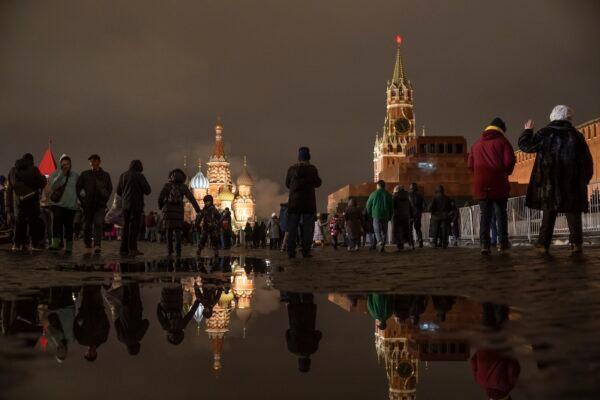 People walk in the Red Square prior to its closure for celebrations on the New Year's Eve, with the St. Basil's Cathedral, left, and the Spasskaya Tower, right, in Moscow, Russia, on Dec. 31, 2022. (Alexander Zemlianichenko/AP photo)