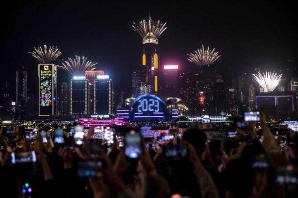 Revelers watch a fireworks and laser show as they celebrate the New Year next to Victoria Harbour in Hong Kong on Jan. 1, 2023. (Isaac Lawrence/AFP via Getty Images)