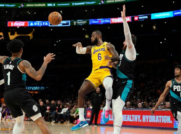 LeBron James (6) of the Los Angeles Lakers makes a no-look pass to teammate Austin Reaves (not pictured), as James is guarded by Jusuf Nurkic (27) of the Portland Trail Blazers in the second half in Los Angeles, on November 30, 2022. (Kevork Djansezian/Getty Images)