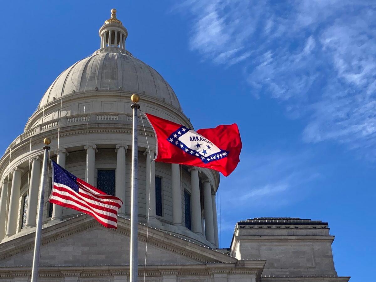 The Arkansas State flag and U.S. flag fly in front of the State Capitol in Little Rock, Ark., on Dec. 1, 2022. (Janice Hisle/The Epoch Times)