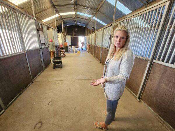 Simone Netherlands, president of the Salt River Wild Horse Management Group, shows the private stalls where newly arrived Alpine wild horses will stay for the foreseeable future, on Nov. 30, 2022. (Allan Stein/The Epoch Times)
