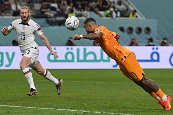 Netherlands' forward (10) Memphis Depay (R) heads the ball past USA's defender (13) Tim Ream during the Qatar 2022 World Cup round of 16 football match between the Netherlands and USA at Khalifa International Stadium in Doha, Qatar, on Dec. 3, 2022. (Alberto Pizzoli/AFP via Getty Images)