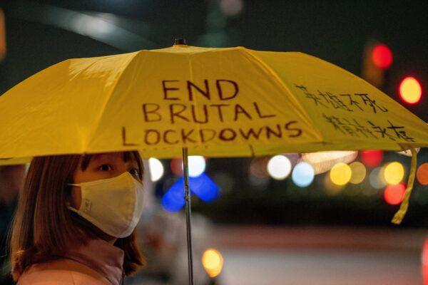 A person holding an umbrella with a slogan on it takes part in anti-CCP protests, amid China's "zero-COVID" policy, near the Chinese Consulate in New York on Nov. 29, 2022. (David 'Dee' Delgado/Reuters)