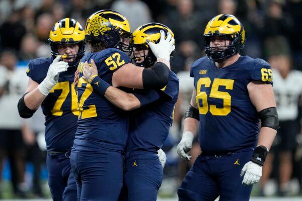 Michigan quarterback J.J. McCarthy is congratulated by teammates Kechaun Bennett (52), Ryan Hayes, (L), and Zak Zinter (65) after throwing a touchdown pass during the second half of the Big Ten championship NCAA college football game against Purdue in Indianapolis, on Dec. 3, 2022. (Darron Cummings/AP Photo)
