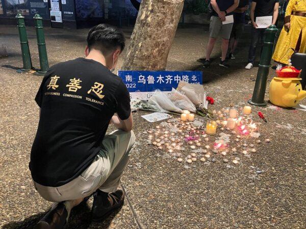 Supporters at a rally in Sydney, Australia, on Dec. 3, 2022, light candles to remember those who perished in the man-made tragedy apartment fire in Urumqi, Xinjiang, under China's harsh zero-COVID lockdown restrictions. (Melanie Sun/The Epoch Times)